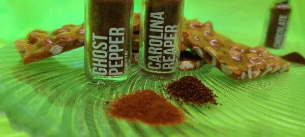 This image is showing the peanut brittle with some of the chili peppers such as ghost pepper and Carolina Reaper that is incorporated into the peanut brittle